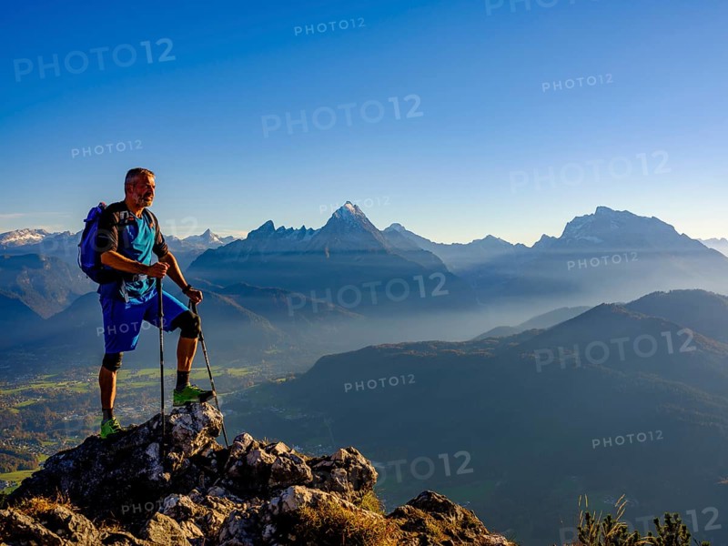 Mountaineer at the summit Rauher Kopf looking at the Berchtesgaden Alps