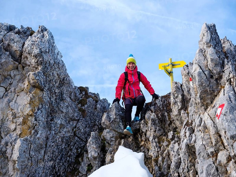 Mountaineer climbing over a rocky saddle