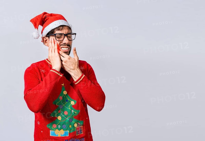 Man in christmas sweater with toothache