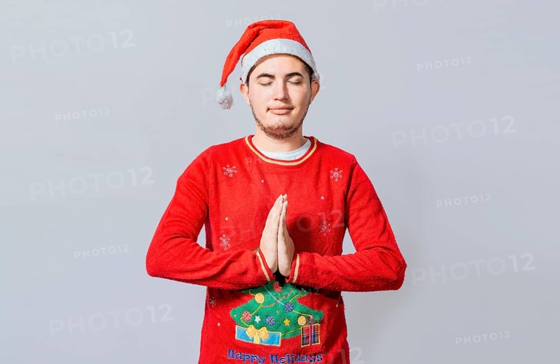 Guy with hands together praying in christmas isolated