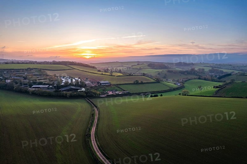Sunset over fields and Widdicombe Farm from a drone