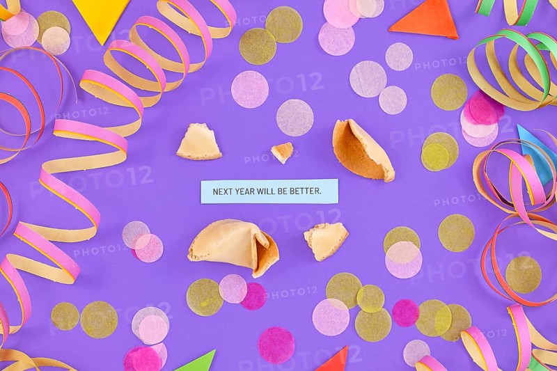 Motivational New Year celebration concept with open fortune cookie and text Next year will be great on colorful background with paper streamers and confetti