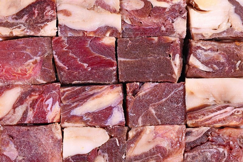 Big chunks of streaked red raw horse meat with lots of fat used for raw feeding of dogs or cats