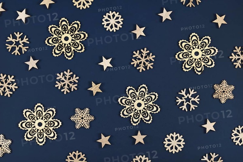 Christmas flat lay with golden snowflake and star ornaments on dark blue background