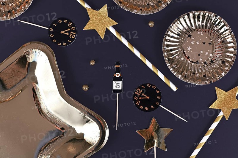 Silvester flat lay with paper Champaign flutes and clocks close to midnight