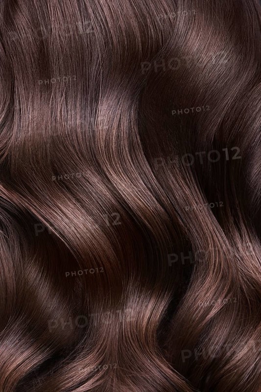 A closeup view of a bunch of shiny curls brown hair