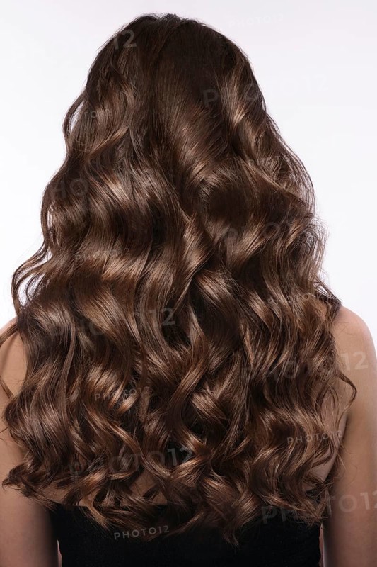 A closeup view of a bunch of shiny curls brown hair