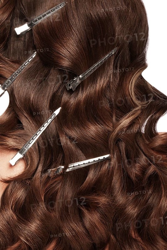 A closeup view of a bunch of shiny curls brown hair