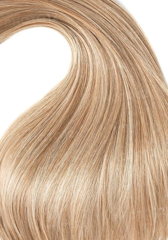 A strand of blond hair on a white background. Close-up