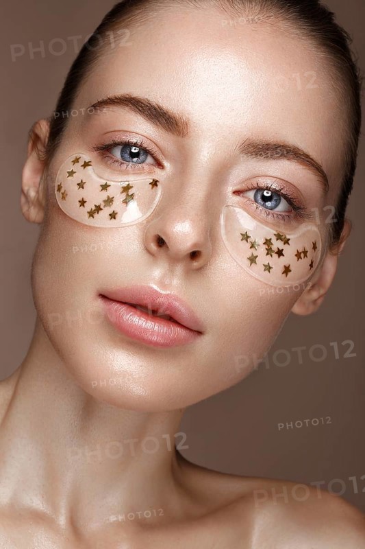 Beautiful fresh girl with cosmetic patches under the eyes