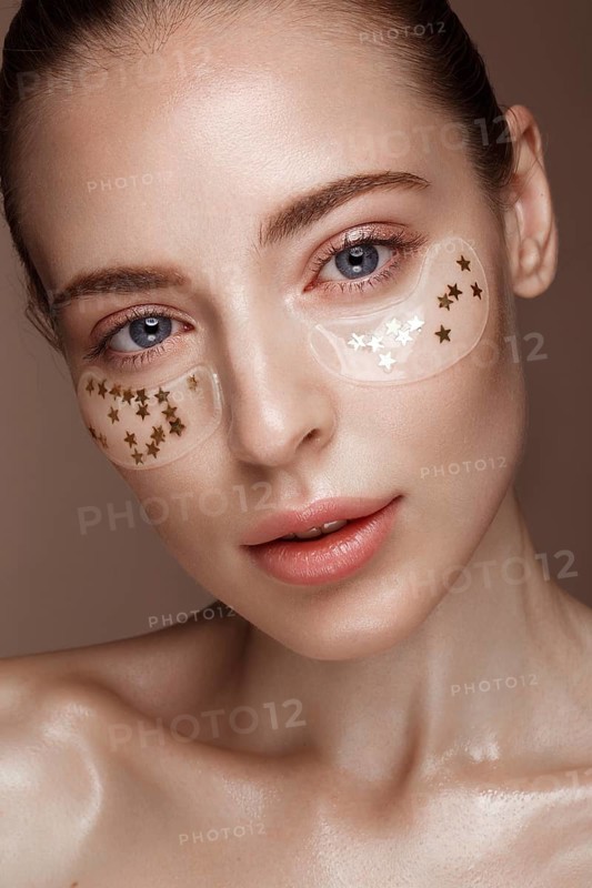 Beautiful fresh girl with cosmetic patches under the eyes