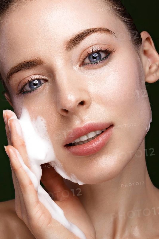 Beautiful young girl with cream on the skin. Beauty face. Picture taken in the studio