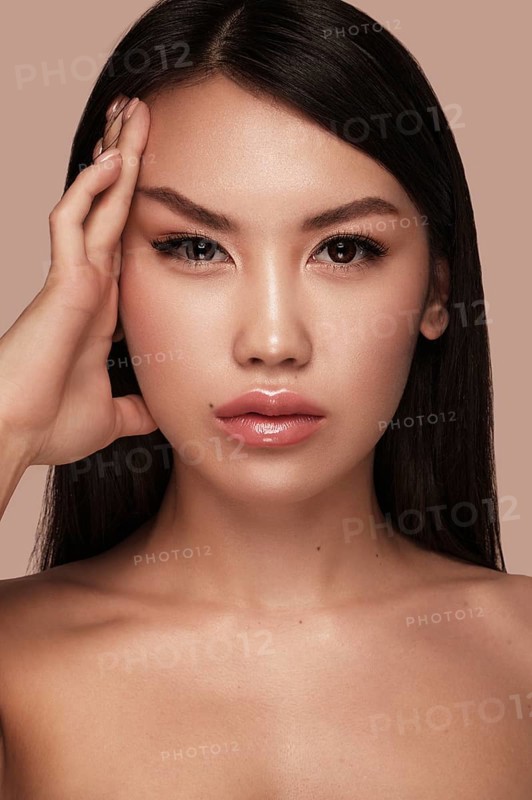 Beautiful delicate woman of oriental type with nude makeup and perfect skin. Beauty face. Spa salon