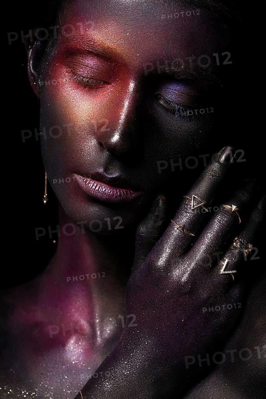 Beautiful girl with art space makeup on her face and body. Glitter Face. Photo taken in the studio