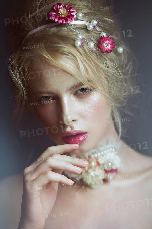 Beautiful blond fashion girl with flowers on the neck and in her hair