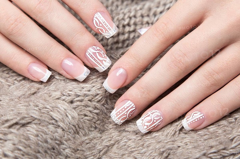 Snow White manicure on female hands. Winter nail design. Picture taken in the studio on a background of wool