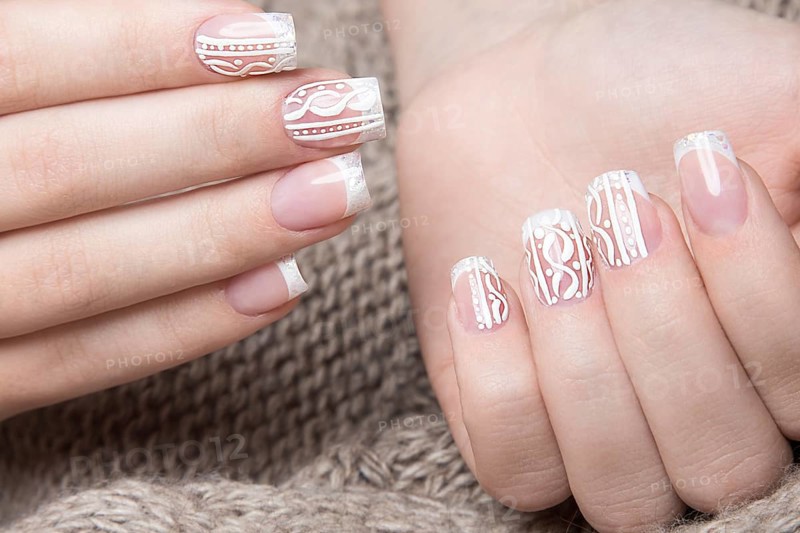 Snow White manicure on female hands. Winter nail design. Picture taken in the studio on a background of wool