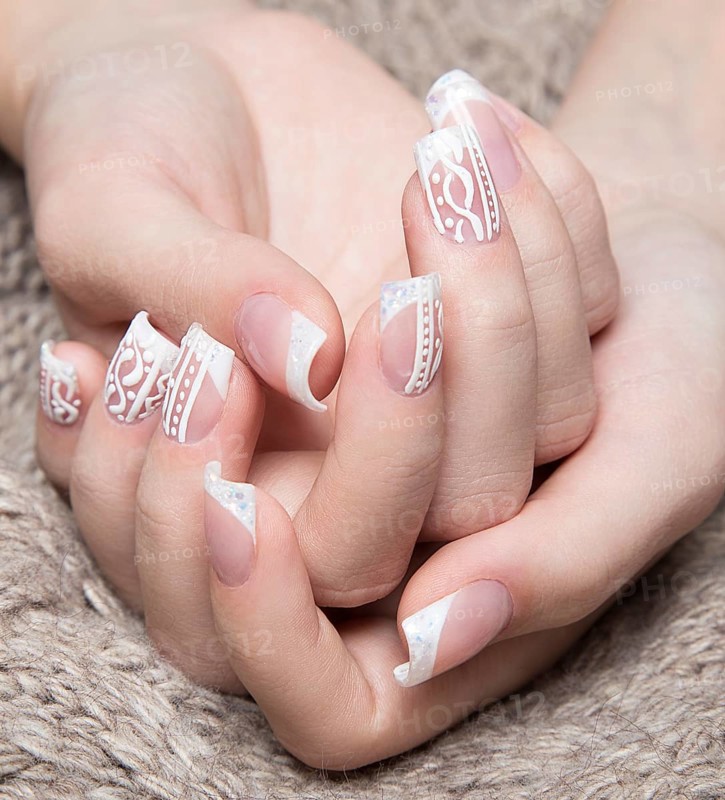 Snow White manicure on female hands. Winter nail design. Picture taken in the studio on a background of wool