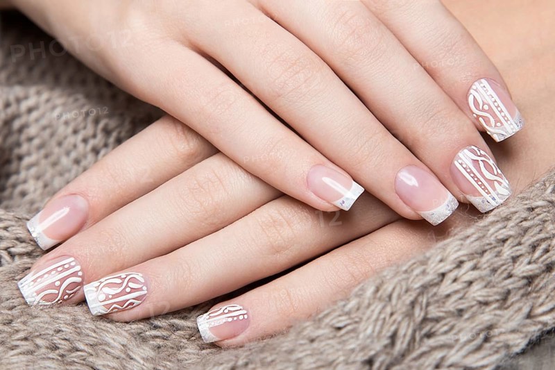 Snow White manicure on female hands. Winter nail design. Picture taken in the studio on a background of wool