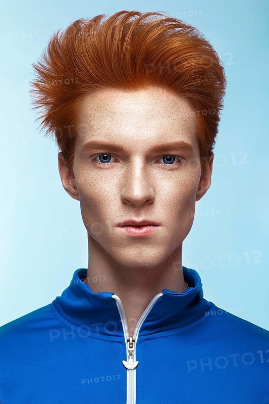 Young man with red hair and creative make up and hair. Photo taken in the studio