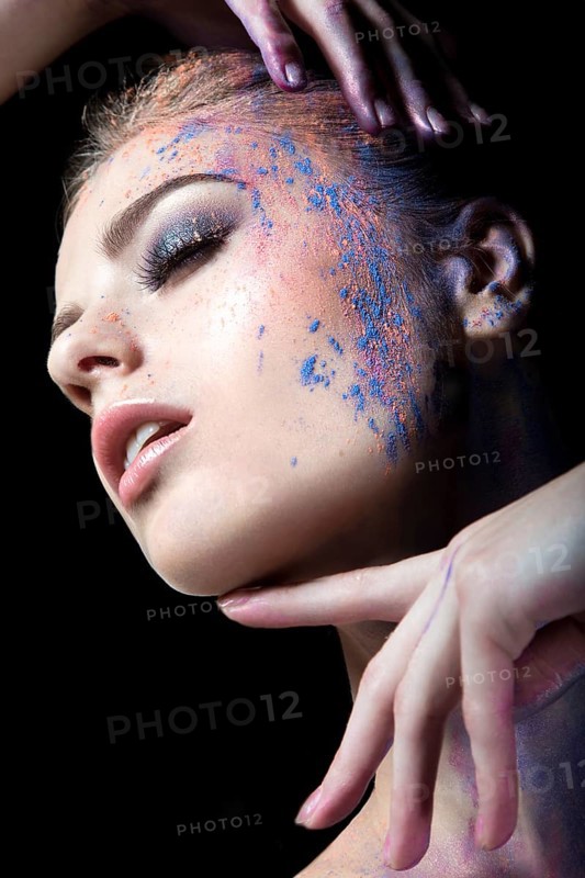 Portrait of a beautiful Girl with red paint on her face. Photo shot in the Studio on a black background