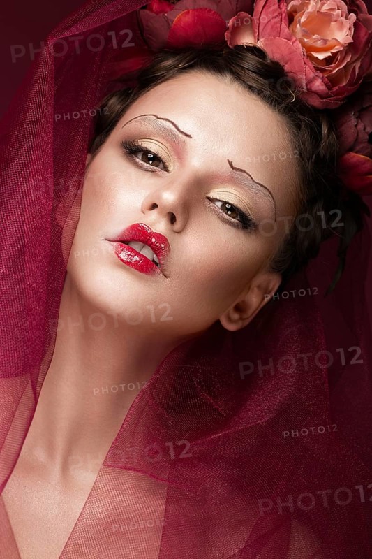 Beautiful girl with art creative make-up in the image of a red bride for Halloween. Beauty face. Photo taken in studio