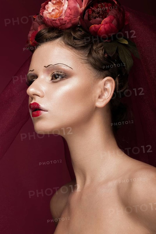 Beautiful girl with art creative make-up in the image of a red bride for Halloween. Beauty face. Photo taken in studio
