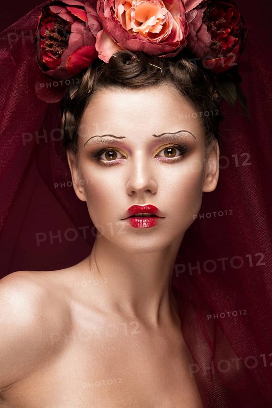 Beautiful girl with art creative make-up in the image of a red bride for Halloween. Beauty face. Photo taken in studio