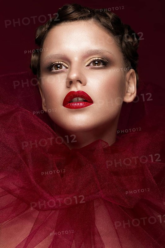 Beautiful girl with art creative make-up in the image of a red bride for Halloween. Beauty face. Photo taken in studio