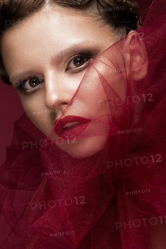 Beautiful girl with art creative make-up in the image of a red bride for Halloween. Beauty face. Photo taken in studio