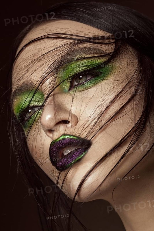 Beautiful girl with spring green makeup and vampire lips. beauty face. Photos shot in studio