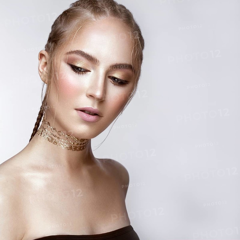 Beautiful girl with a golden shiny make-up and a haircut on her head. Beauty face. Photo taken in the studio