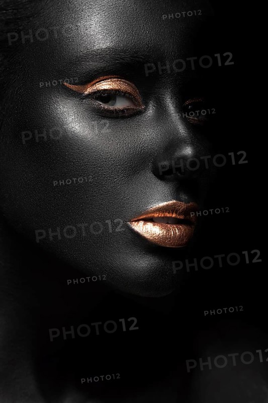Fashion portrait of a dark-skinned girl with color make-up.Beauty face. Picture taken in the studio on a black background