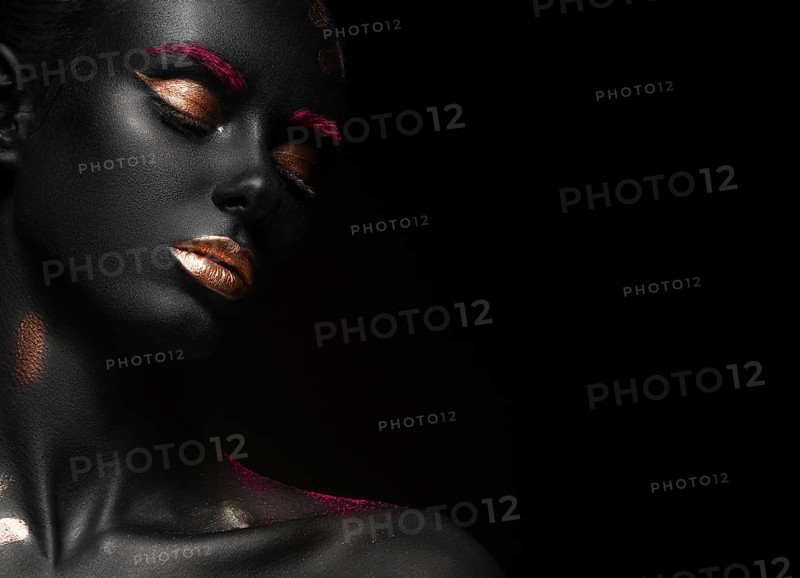 Fashion portrait of a dark-skinned girl with color make-up.Beauty face. Picture taken in the studio on a black background