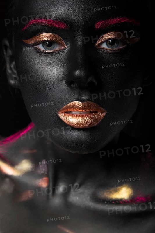 Fashion portrait of a dark-skinned girl with color make-up.Beauty face. Picture taken in the studio on a black background