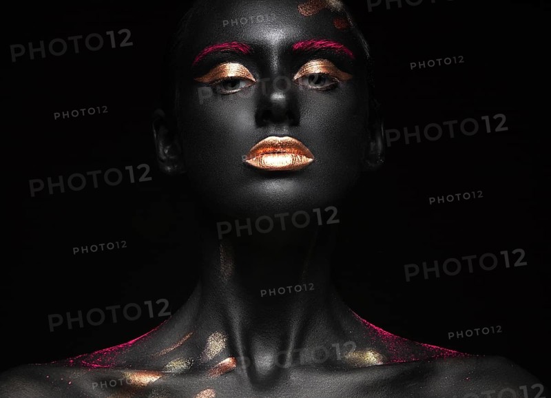 Fashion portrait of a dark-skinned girl with color make-up.Beauty face. Picture taken in the studio on a black background