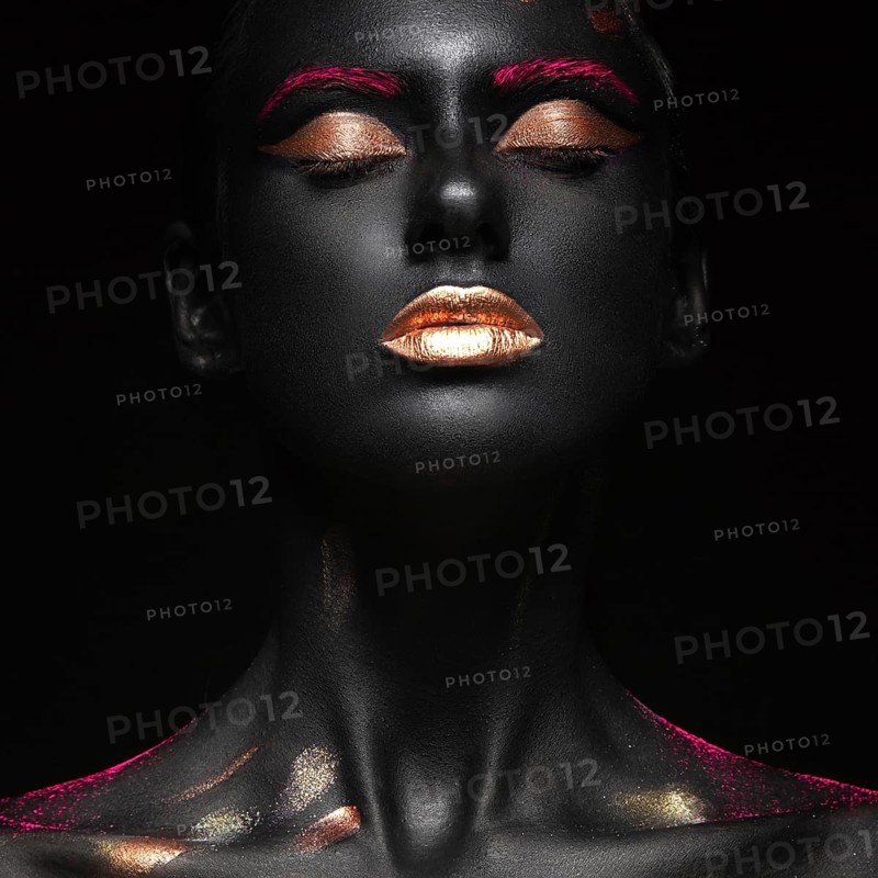 Fashion portrait of a dark-skinned girl with color make-up.Beauty face. Picture taken in the studio on a black background