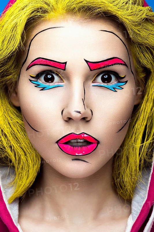 Photo of surprised young woman with professional comic pop art make-up. Creative beauty style. Photos shot in studio