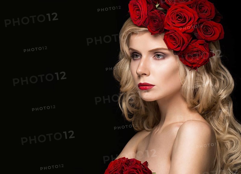 Beautiful blond girl in a dress and hat with roses