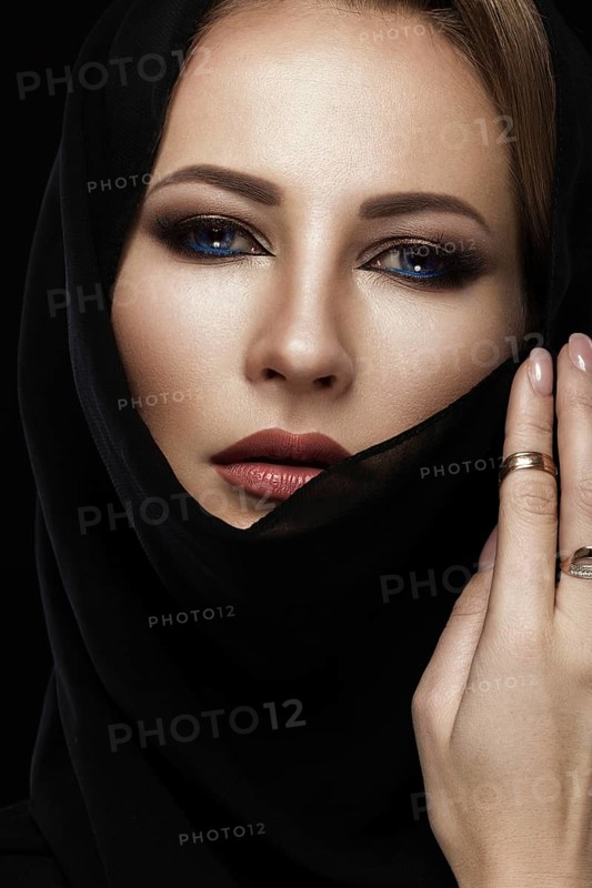 Beautiful girl in the Arab scarf with oriental make-up. Beauty face. Photos shot in the studio