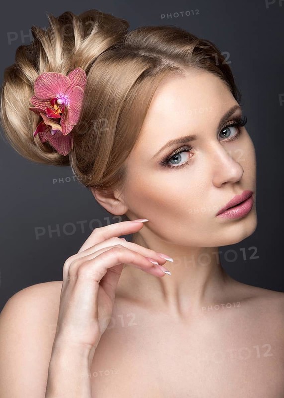 Portrait of a beautiful woman in the image of the bride with flowers in her hair. Picture taken in the studio on a black background