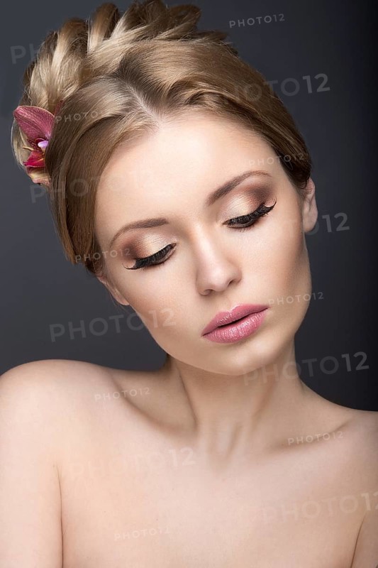 Portrait of a beautiful woman in the image of the bride with flowers in her hair. Picture taken in the studio on a black background