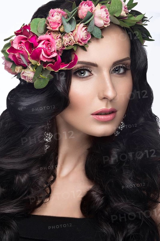 Portrait of a beautiful woman in the image of the bride with flowers in her hair. Picture taken in the studio on a black background