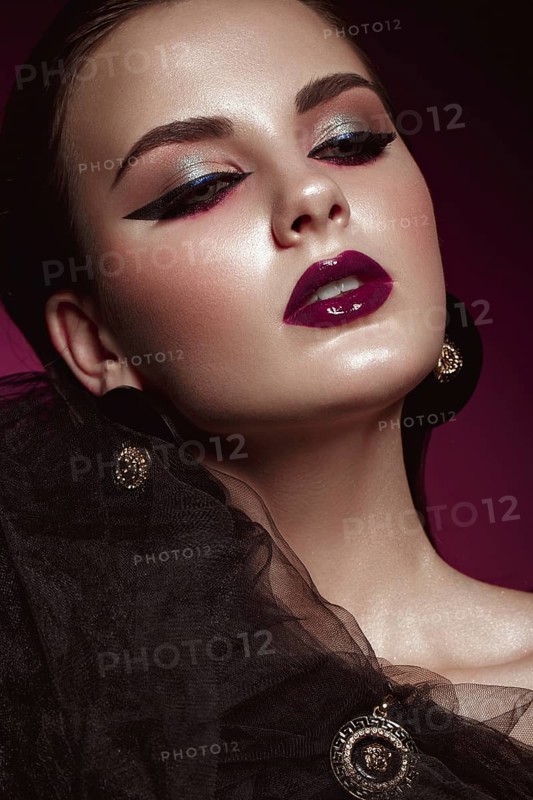 Beautiful girl with bright creative make-up and graphic arrows. Beauty face. Photos shot in studio