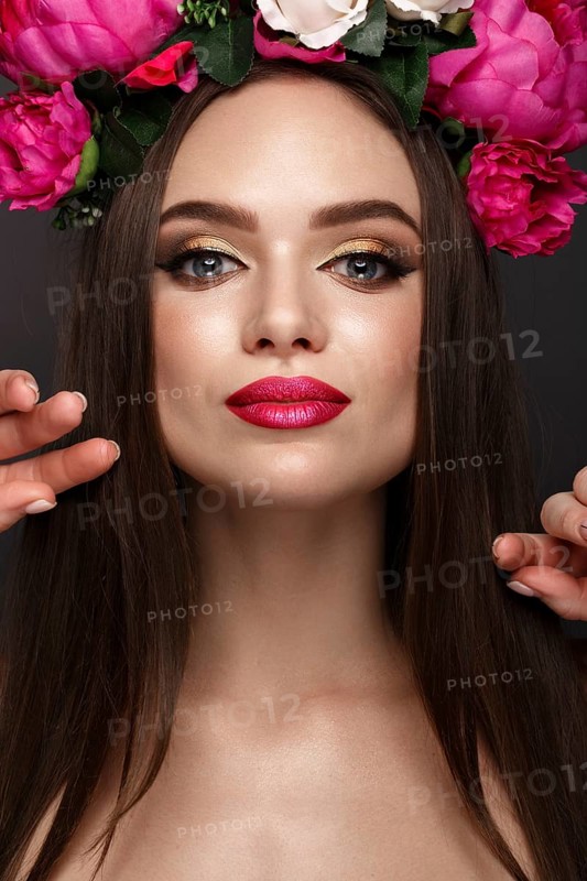 Beautiful girl with bright make up and flowers on her head. Beauty face. Photos shot in studio