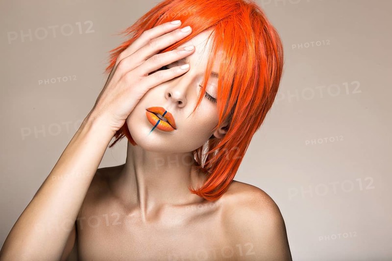 Beautiful girl in an orange wig cosplay style with bright creative lips. Art beauty image. Portrait shot in the studio