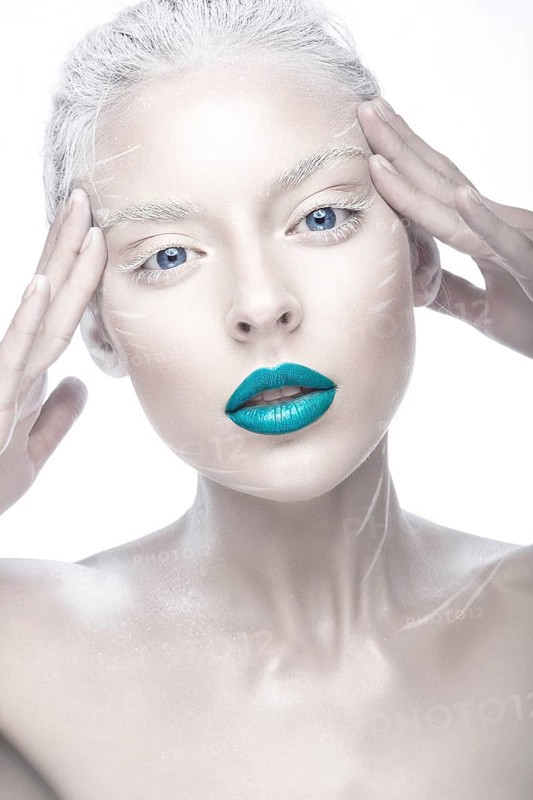 Beautiful girl in the image of albino with blue lips and white eyes. Art beauty face. Picture taken in the studio on a white background