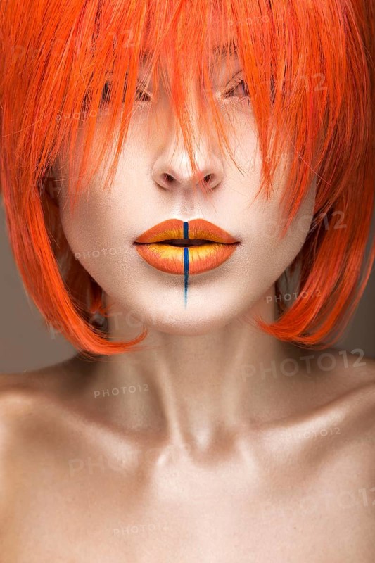 Beautiful girl in an orange wig cosplay style with bright creative lips. Art beauty image. Portrait shot in the studio