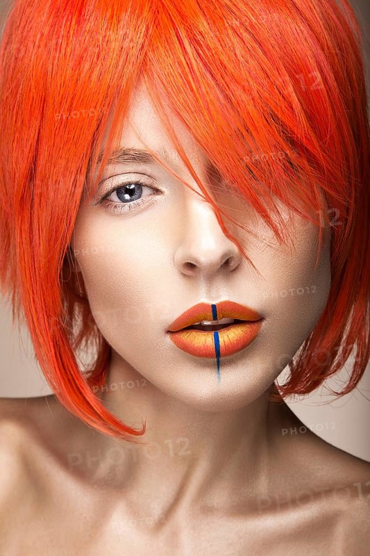 Beautiful girl in an orange wig cosplay style with bright creative lips. Art beauty image. Portrait shot in the studio