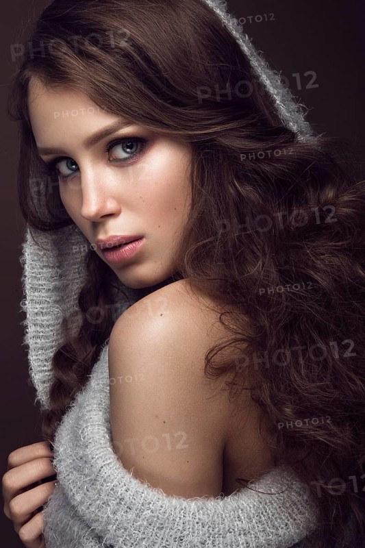 Beautiful young girl with gentle make-up in warm sweater and long straight hair. Beauty face. Studio portrait